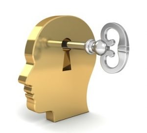 Ein goldener Kopf in dem ein Schlüsselloch ist mit einem silbernen Schlüssel der darin steckt.